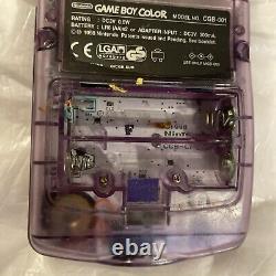 Console Nintendo Gameboy Color transparente violette atomique sans couvercle de batterie manquant.