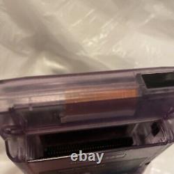 Console Nintendo Gameboy Color transparente violette atomique sans couvercle de batterie manquant.